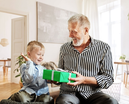Großvater gibt seinem Enkel ein Geschenk, welcher sich sehr freut